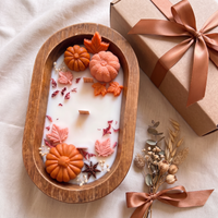 Pumpkin dough bowl candle beside gift box, ribbon and dried flowers