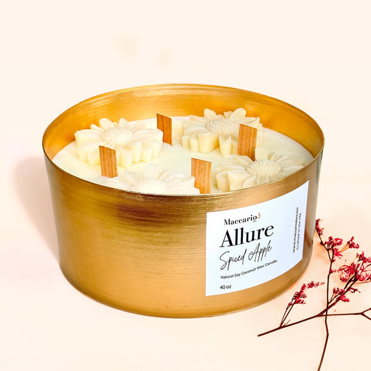 A large gold jar soy coconut wax candle with a label that reads 'Allure Spiced Apple'. The candle is scented with apple spice and has a creamy white color, filling the jar with a warm, inviting aroma.